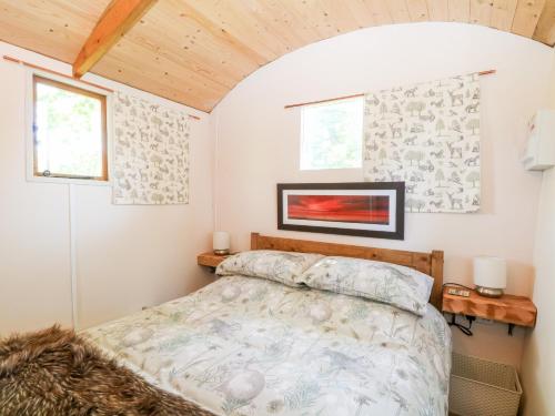 a bedroom with a bed and two windows at Hugatree in Little Dunham