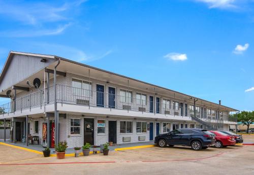 a building with cars parked in a parking lot at Knights Inn North Richland Hills in North Richland Hills