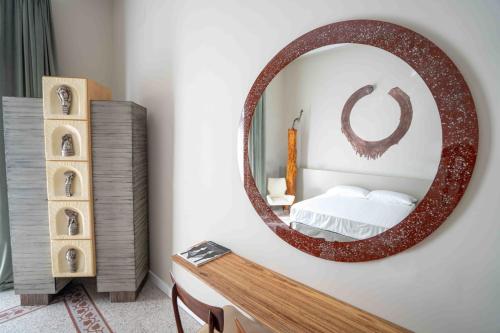 - une chambre avec un grand miroir circulaire sur le mur dans l'établissement Atelier Inès Arts & Suites, à Naples