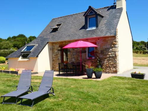 une maison avec deux chaises et un parapluie rose dans l'établissement La Douce Escapade - Crozon, à Crozon