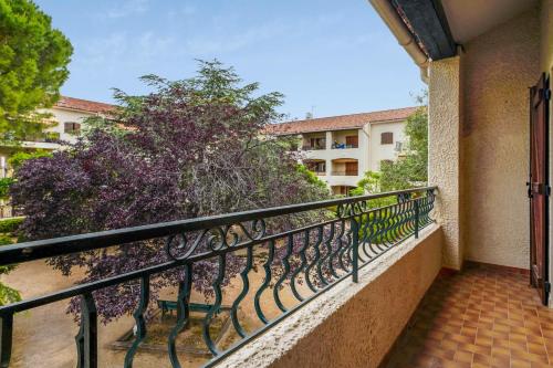 een balkon met een zwarte leuning en een boom bij Appartement Cyria - Welkeys in Saint-Cyr-sur-Mer