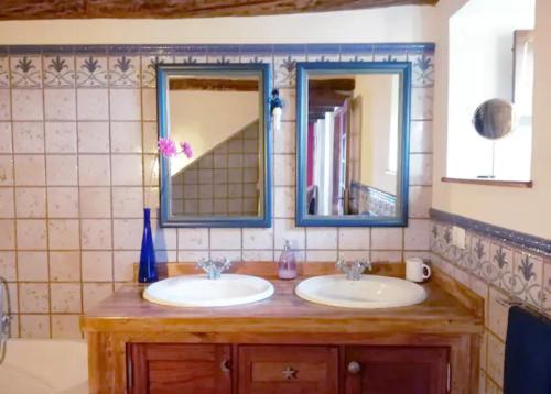 a bathroom with two sinks and two mirrors at Casa Rural Los Mozos in Guarazoca