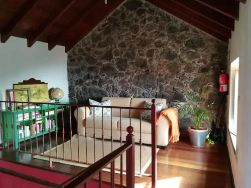 a living room with a couch and a stone wall at Casa Rural Los Mozos in Guarazoca