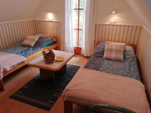 Habitación pequeña con 2 camas y mesa. en Tamás Bátya Kunyhója en Balatonmáriafürdő