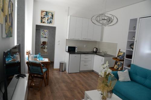 a living room with a blue couch and a kitchen at Apartment Krins in Novi Sad