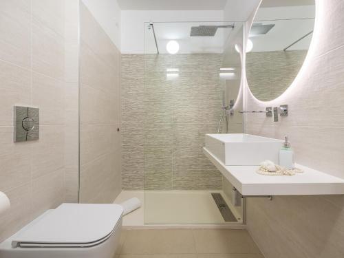 a bathroom with a toilet and a sink and a shower at Palazzo Michelangelo in Villasimius