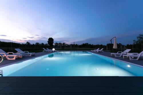 a large swimming pool with lounge chairs at Country House Campofiore in Pontelongo