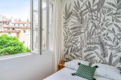 une chambre avec un lit et une grande fenêtre dans l'établissement Appartement Liberty - Welkeys, à Marseille