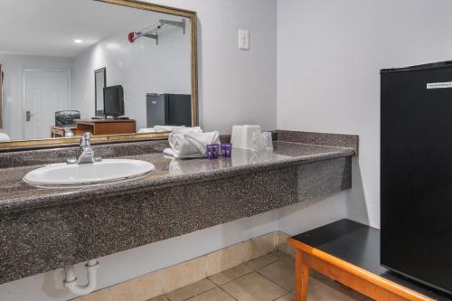 een badkamer met een wastafel en een spiegel bij Knights Inn North Richland Hills in North Richland Hills