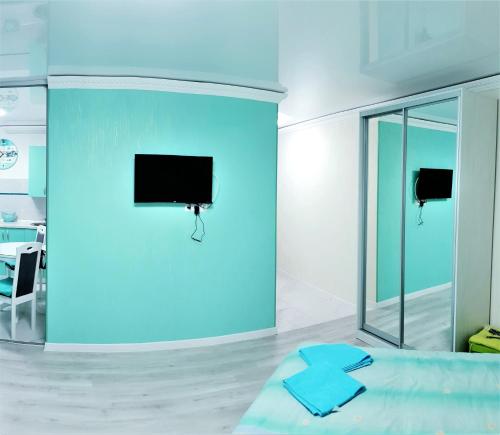 um quarto azul com uma cama e uma televisão na parede em Tiffany apartment in the center em Dnipro