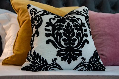 a black and white pillow on a bed with pillows at Apple Tree Bed and Breakfast in Tavistock