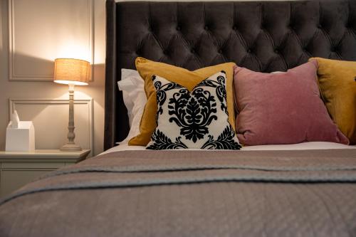 a bed with a black headboard and pillows at Apple Tree Bed and Breakfast in Tavistock