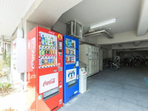 two vending machines are in a garage with bikes at HOTEL Nishikawaguchi Weekly - Vacation STAY 44797v in Saitama