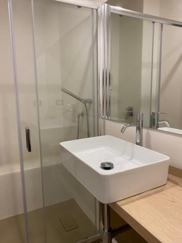 W łazience znajduje się biała umywalka i prysznic. w obiekcie Delle Palme Rooms elegante monolocale in centro w mieście Palermo