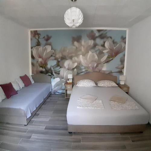 two beds in a room with a flower mural at Vicky Apartments in Kotor