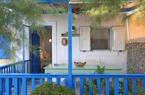 a blue porch with a table and a window at Little Blue in Káto Zákros