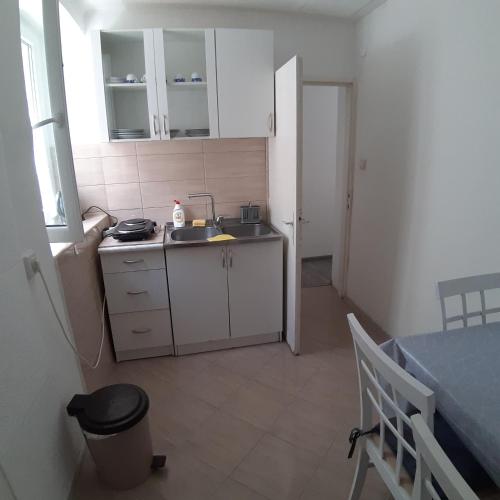 a small kitchen with a sink and a table at Vicky Apartments in Kotor