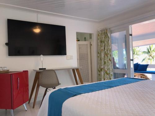 a bedroom with a bed with a television on the wall at Pousada Mestre Augusto in Angra dos Reis