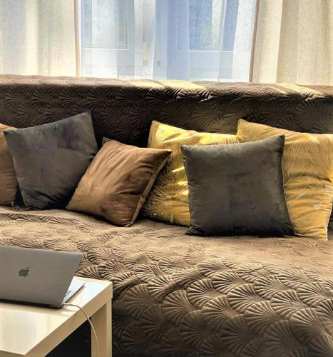 a couch with pillows and a laptop on a table at Vicky - New Apartment Centrum Srodmiescie in Warsaw