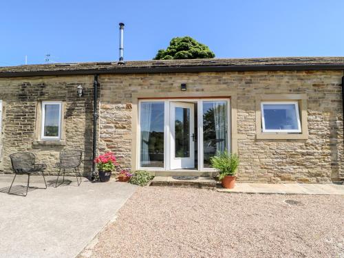 a stone house with windows and chairs in front of it at 1 Barn Cottages in Halifax