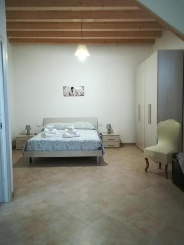 a bedroom with a bed and a chair at Casa Vacanza Da Sofì in Cerda