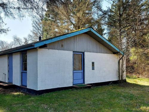 Oddeにある6 person holiday home in Hadsundの庭の青い扉が付いた小さな白い家