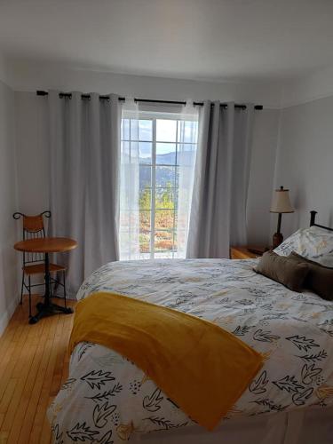 a bedroom with a large bed and a window at La Maison Harvey&Lessard in Tadoussac