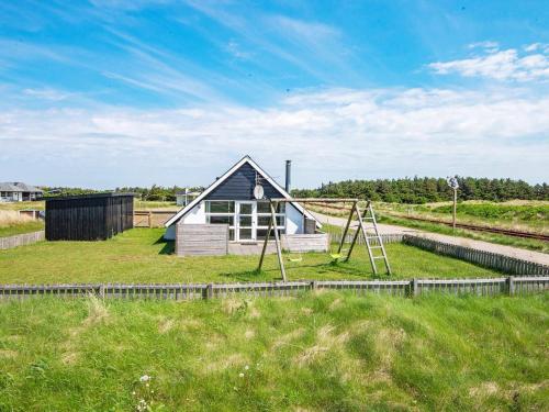 a small house with a playground in a field at 6 person holiday home in Harbo re in Harboør