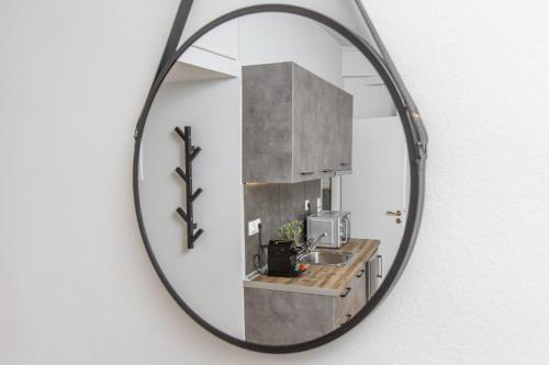 um espelho pendurado numa parede com um lavatório em Raise comfy studios in the heart of Athens em Atenas