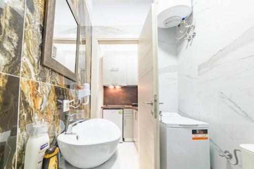 a white bathroom with a sink and a toilet at Bella Partenza Studio in Corfu