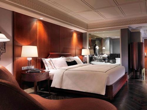 1 dormitorio con 1 cama grande y espejo grande en Hotel Muse Bangkok Langsuan - MGallery, en Bangkok