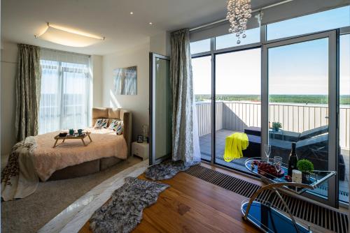 a bedroom with a bed and a large window at Skyhouse Riga Private Penthouse and SPA in Rīga