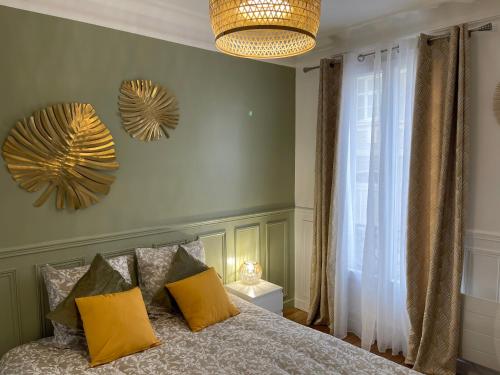 a bedroom with a bed with yellow pillows at Bella Mia - Chic apartment near Orly Rport 15mns frm Paris in Choisy-le-Roi
