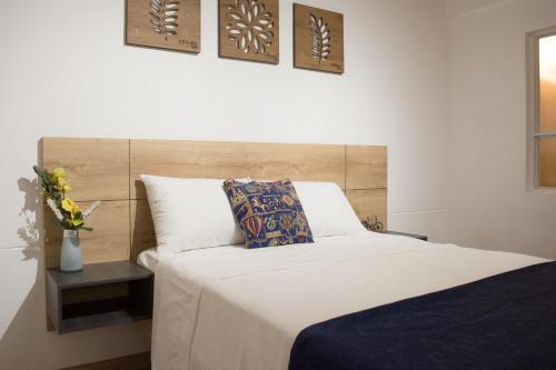 a bedroom with a large bed and a vase of flowers at Azalea Hotel in Zipaquirá