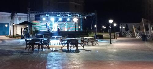 a group of tables and chairs and lights at night at Aqua view North coast-الكيلو 91- in El Alamein