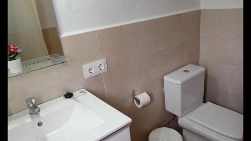 a bathroom with a sink and a toilet and a mirror at El Pez Naranja in Zahara de los Atunes