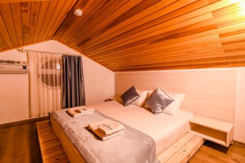 a bed in a room with a wooden ceiling at Kybele Suites in Kaş