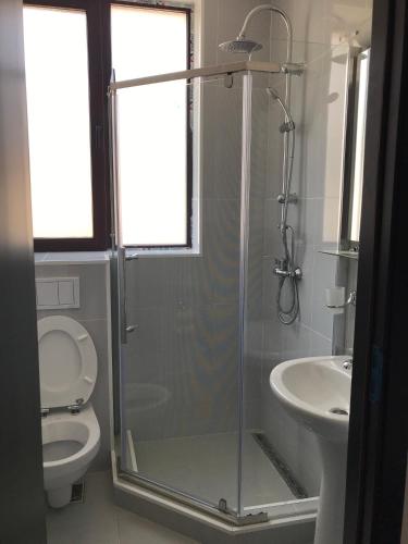 a bathroom with a shower and a toilet and a sink at Matei Mamaia-Nord in Mamaia Sat/Năvodari