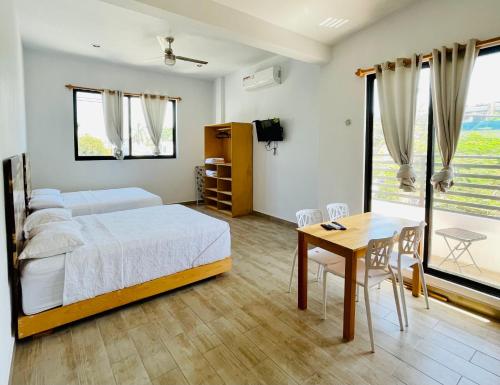 - une chambre avec un lit, une table et des chaises dans l'établissement SuitesMB, à Playa del Carmen