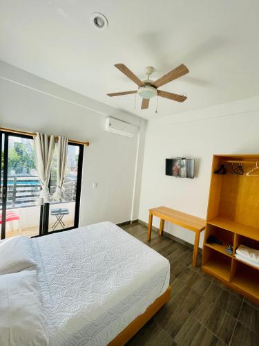 a bedroom with a bed and a ceiling fan at SuitesMB in Playa del Carmen
