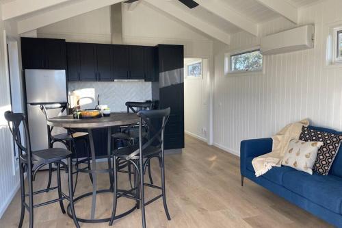 a kitchen with a table and chairs and a blue couch at Wallinga Farmstay Mudgee in Mudgee