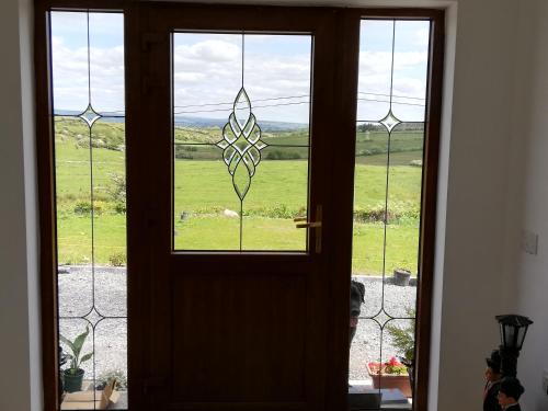 eine Tür mit einem Fenster mit Blick auf ein Feld in der Unterkunft Peace and Tranquility in Ballymote