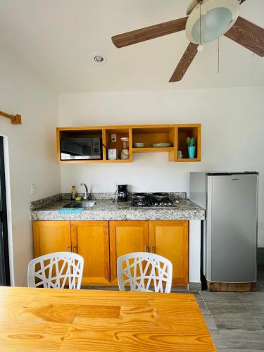 a kitchen with a stainless steel refrigerator and white chairs at SuitesMB in Playa del Carmen