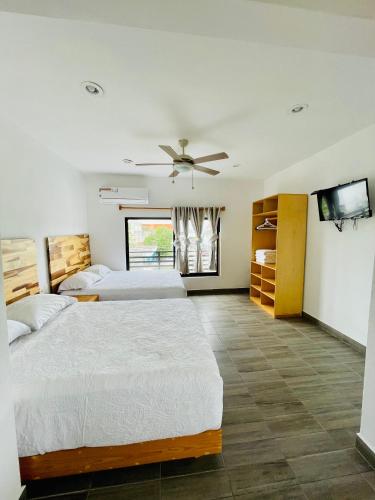 a bedroom with two beds and a flat screen tv at SuitesMB in Playa del Carmen