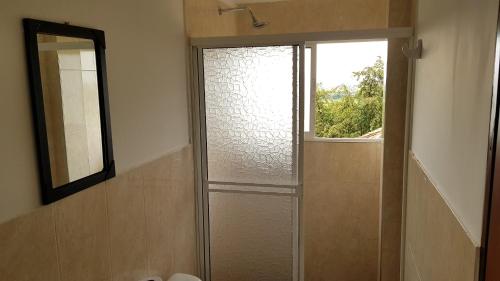 een badkamer met een douche, een raam en een spiegel bij Dedalos Fly House in Palmira