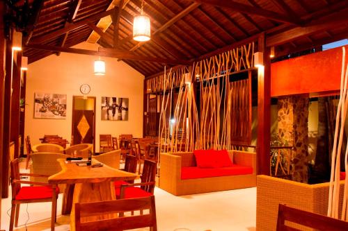 a living room with a red couch and a table at D'Wahana Resort in Gili Trawangan