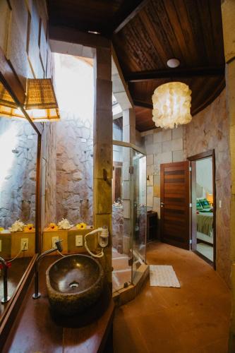 a bathroom with a large tire sink and a shower at Paua Hotel Boutique in Pipa