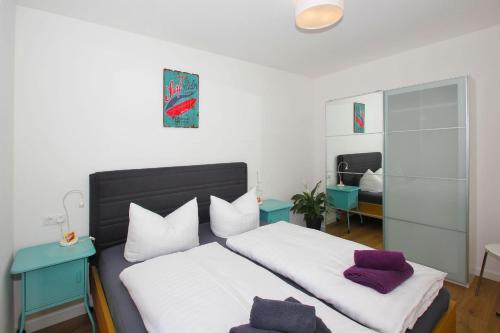 - une chambre avec 2 lits dotés d'oreillers blancs et violets dans l'établissement F-1093 Villa Elise Ferienwohnung Nr 01, à Göhren
