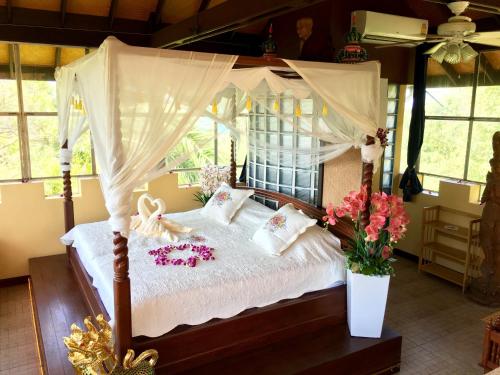 ein Schlafzimmer mit einem Himmelbett mit Blumen darauf in der Unterkunft Ever dreamed of staying in a 3 Bedroom Castle-SDV044B-By Samui Dream Villas in Koh Samui 