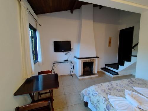 Televisyen dan/atau pusat hiburan di Pousada Villa de charme hospedagem com hidromassagem e lareira